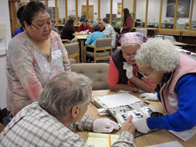 Debbie Nictune, Jean Stevens and Florence Nictune looking at historic photographs with faculty member Bill Schneider in the Alaska and Polar Regions Collections and Archives, November 11, 2009