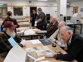 L-R:  Clutch Lounsbury, Syd Stealey, and Bill English look at historic photographs at the Alaska and Polar Regions Collections and Archives, March 27, 2012.