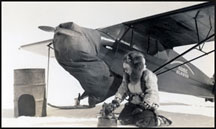 photo of a woman starting a heater under an airplane