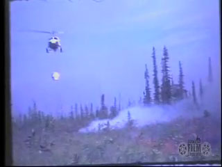 Bell UH-1 Huey drops water on Vundik Lake fire
