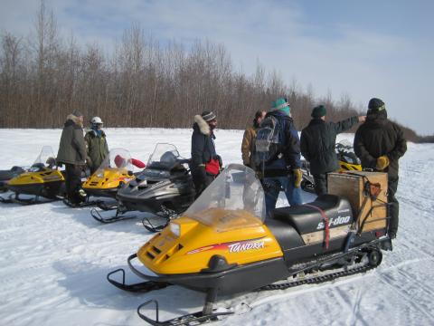 Dangerous Ice Project team members and snowmachines gathered on the frozen Tanana River